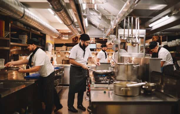 Restaurant kitchen crew preparing food.